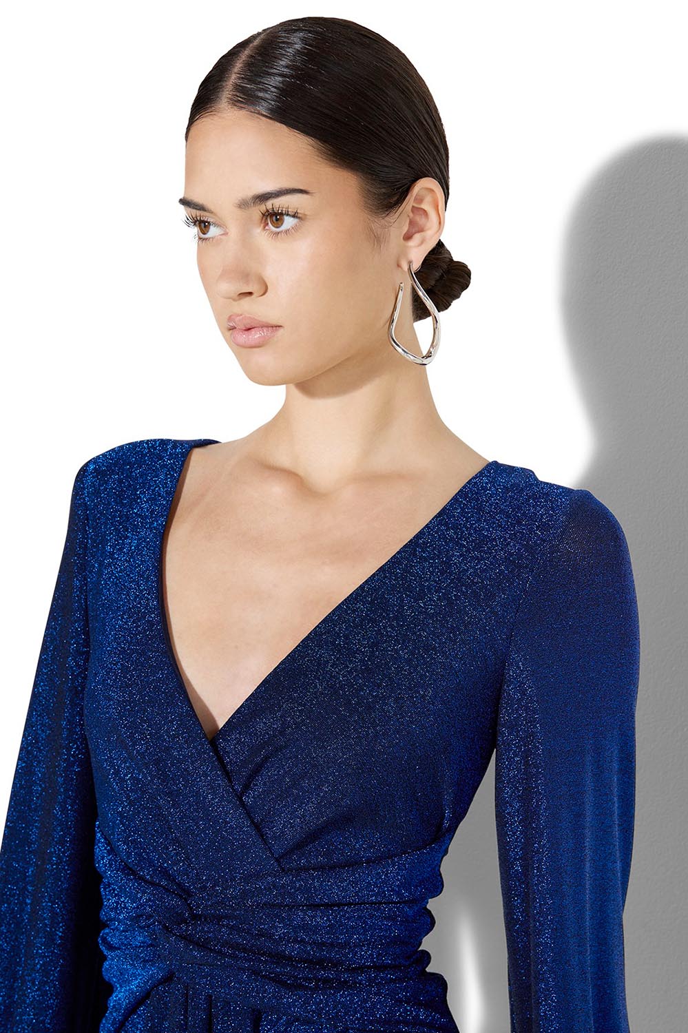 A model wearing the Serena Shimmer Maxi Gown in colour Sapphire (Blue), from the front, cropped image