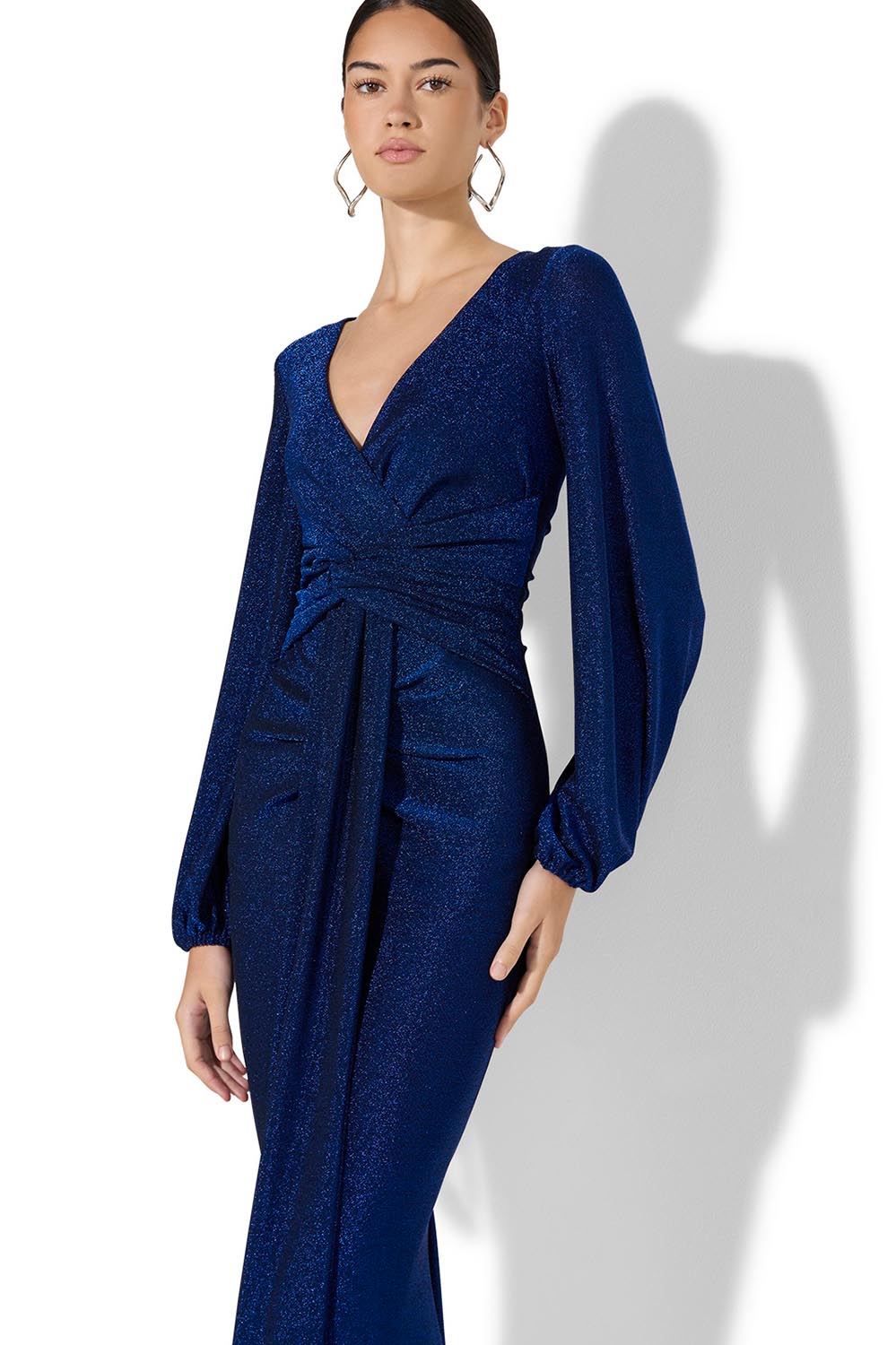 A model wearing the Serena Shimmer Maxi Gown in colour Sapphire (Blue), from the front, cropped image