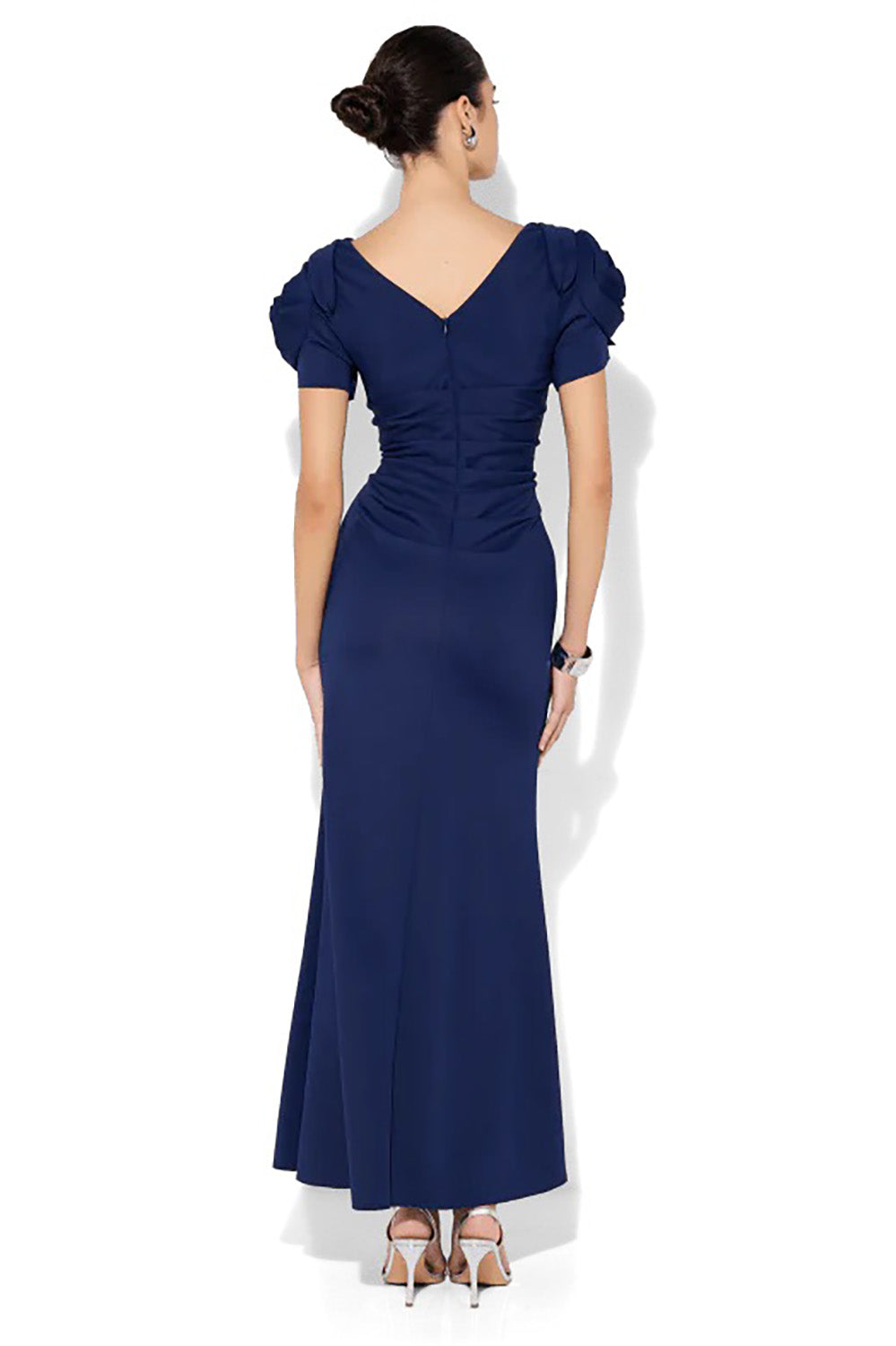 A model wearing the Monet Rosette Sleeve Gown in colour Navy (Blue), from the back