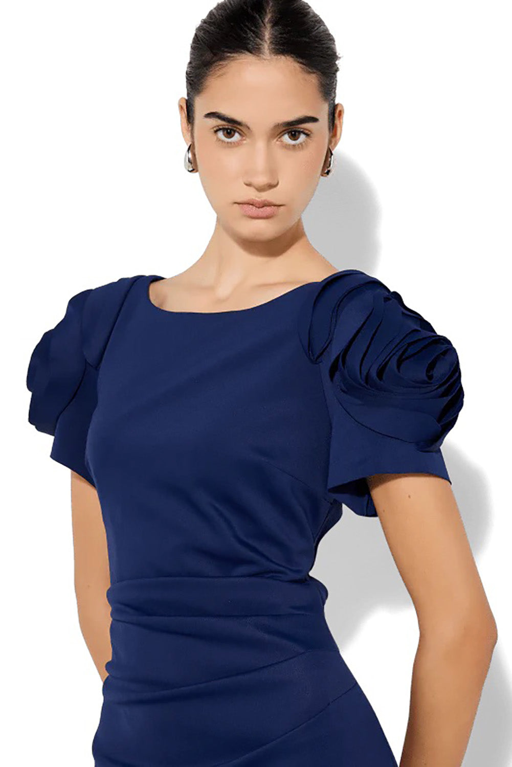 A model wearing the Monet Rosette Sleeve Gown in colour Navy (Blue), from the front, cropped image