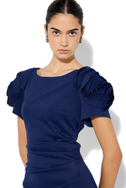 A model wearing the Monet Rosette Sleeve Gown in colour Navy (Blue), from the front, cropped image