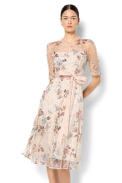 A model wearing the Pippa Embroidered Dress in colour Mink (Pink), from the front, cropped image