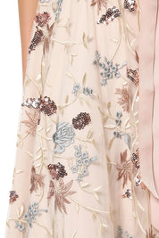 A model wearing the Pippa Embroidered Dress in colour Mink (Pink), from the front, showing the whole outfit