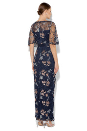 A model wearing the Florence Navy Embroidered Gown in colour Navy (Blue), from the back