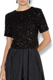 A model wearing the Ginger Sequin Top in colour Black (Black), from the front, cropped image