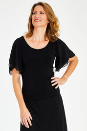 Model Naomi wearing size 10 of the Brenda Top in colour Black (Black), from the front, cropped image