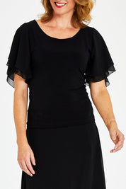 Model Naomi wearing size 10 of the Brenda Top in colour Black (Black), from the front, cropped image