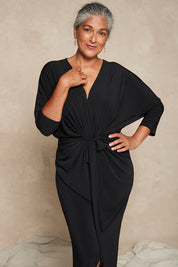 Model Nadine wearing size 10 of the Nadine Dress in colour Black (Black), from the front, showing the whole outfit