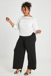Model Alexis wearing size 16 of the Tia Blouse in colour Ivory (White), from the front, showing the whole outfit