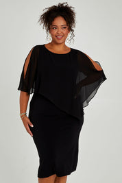 Model Alexis wearing size 16 of the Cassandra Dress in colour Black (Black), from the front, cropped image