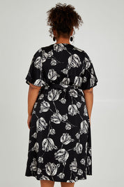 Model Alexis wearing size 16 of the Alanah Wrap Dress in colour Tulips (Black), from the back