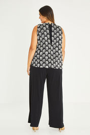 Model Palatina wearing size 16 of the Olivia Jumpsuit in colour Leaf (Black), from the back