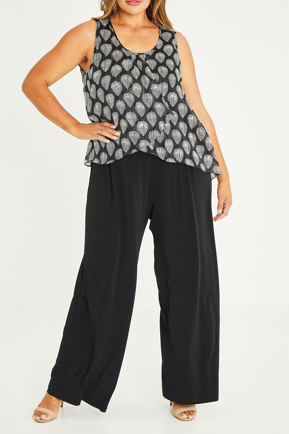 Model Palatina wearing size 16 of the Olivia Jumpsuit in colour Leaf (Black), from the front, cropped image