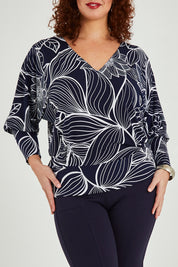 Model Maddy wearing size 16 of The Printed Kelly Blouse in colour Navyleaves (Blue), from the front, cropped image