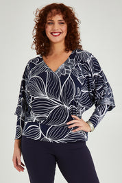 Model Maddy wearing size 16 of The Printed Kelly Blouse in colour Navyleaves (Blue), from the front, cropped image
