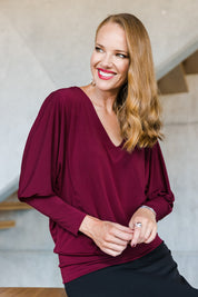 Model Katie wearing size 10 of the Kelly Blouse in colour Port (Red), from the front, showing the whole outfit