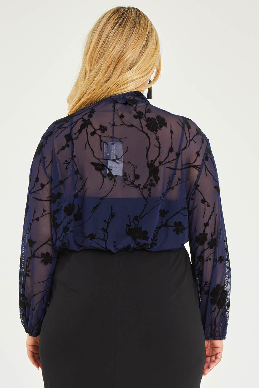 Model Katie wearing size 16 of the Penny Shrug in colour Navyfleur (Blue), from the back