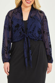 Model Katie wearing size 16 of the Penny Shrug in colour Navyfleur (Blue), from the front, cropped image