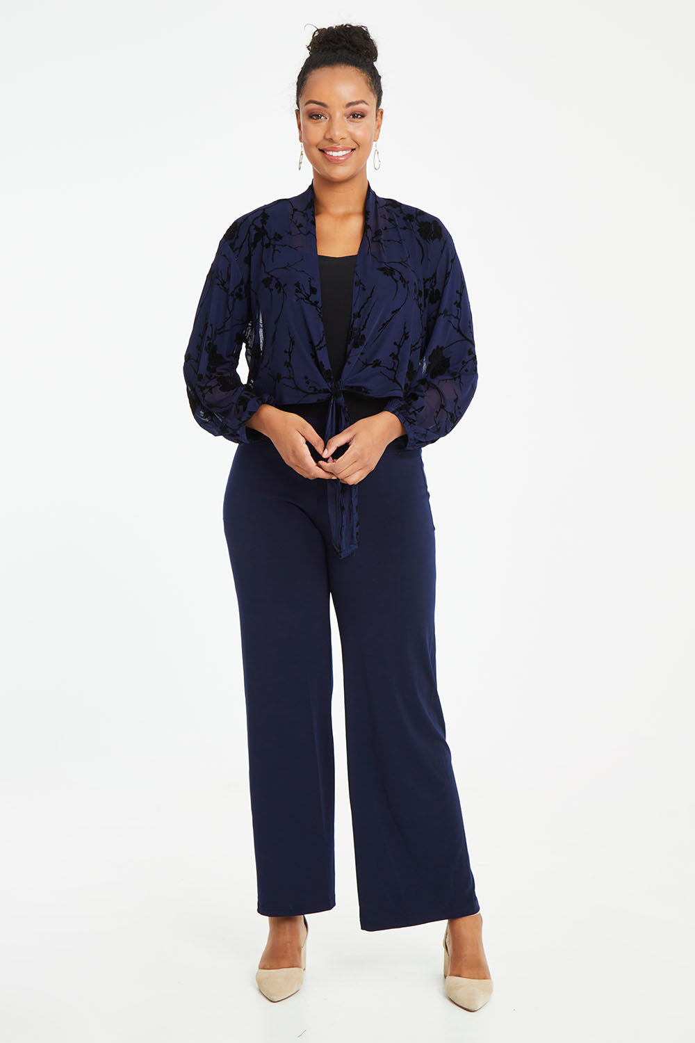 Model Noli wearing size 14 of the Penny Shrug in colour Navyfleur (Blue), from the front, showing the whole outfit