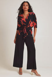 Model Terri-Leigh wearing size 14 of The Printed Niamh Top in colour Firelight (Black), from the front, showing the whole outfit