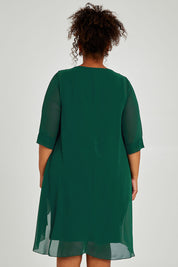 Model Alexis wearing size 16 of the Bethany Dress in colour Pine (Green), from the back