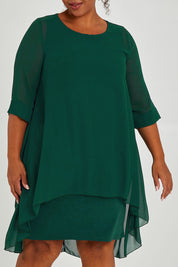 Model Alexis wearing size 16 of the Bethany Dress in colour Pine (Green), from the front, cropped image