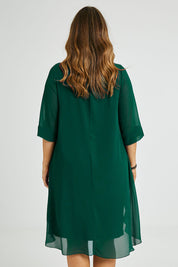 Model Laura wearing size 14 of the Bethany Dress in colour Pine (Green), from the back