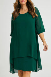 Model Laura wearing size 14 of the Bethany Dress in colour Pine (Green), from the front, cropped image