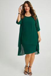 Model Laura wearing size 14 of the Bethany Dress in colour Pine (Green), from the front, showing the whole outfit