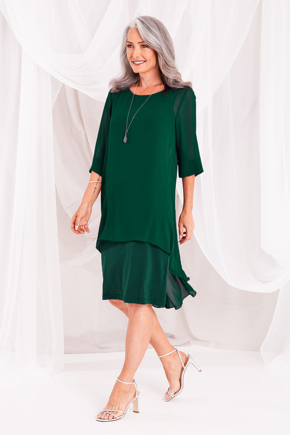 Model Luisa wearing size 10 of the Bethany Dress in colour Pine (Green), from the front, showing the whole outfit