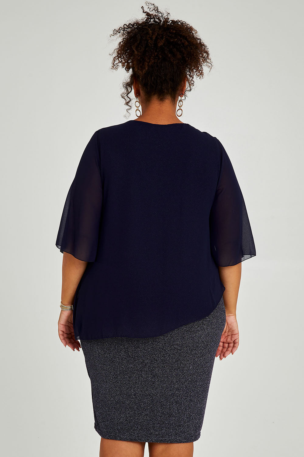Model Alexis wearing size 16 of the Bridgette Dress in colour Navy (Blue), from the back