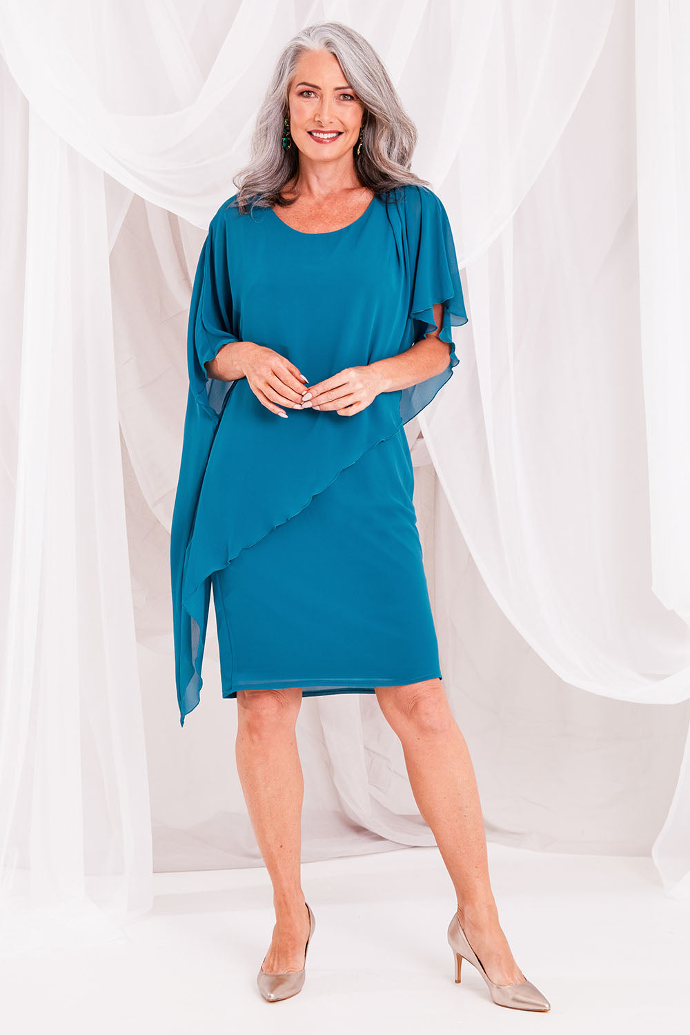 Model Luisa wearing size 10 of the Beatrice Dress in colour Teal (Blue), from the front, showing the whole outfit