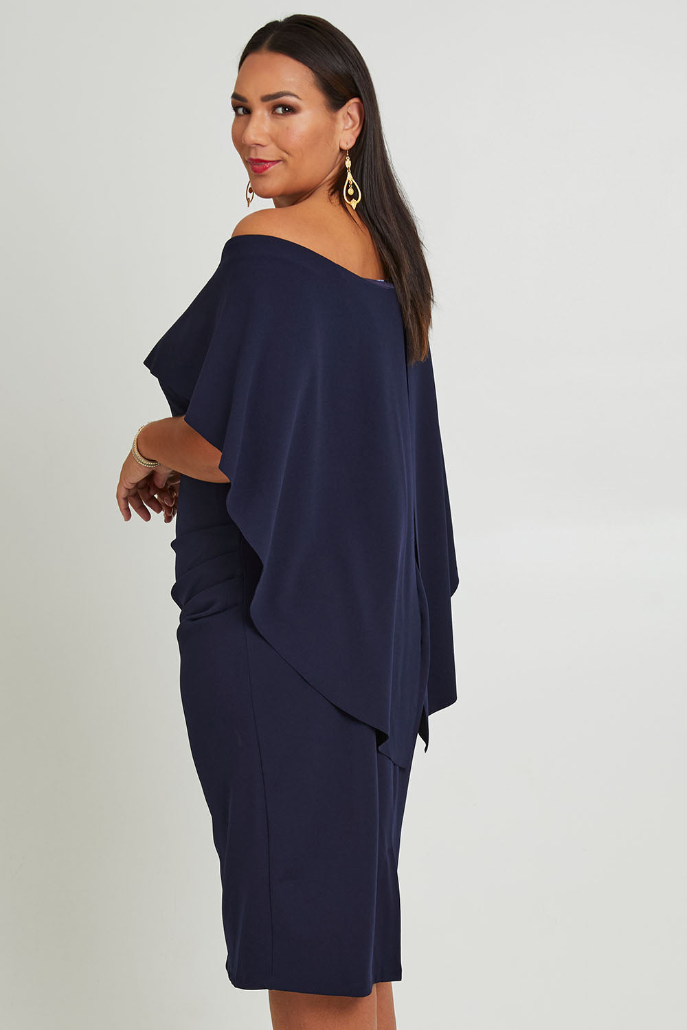 Model Ashleigh wearing size 16 of the Cora Dress in colour Navy (Blue), from the back
