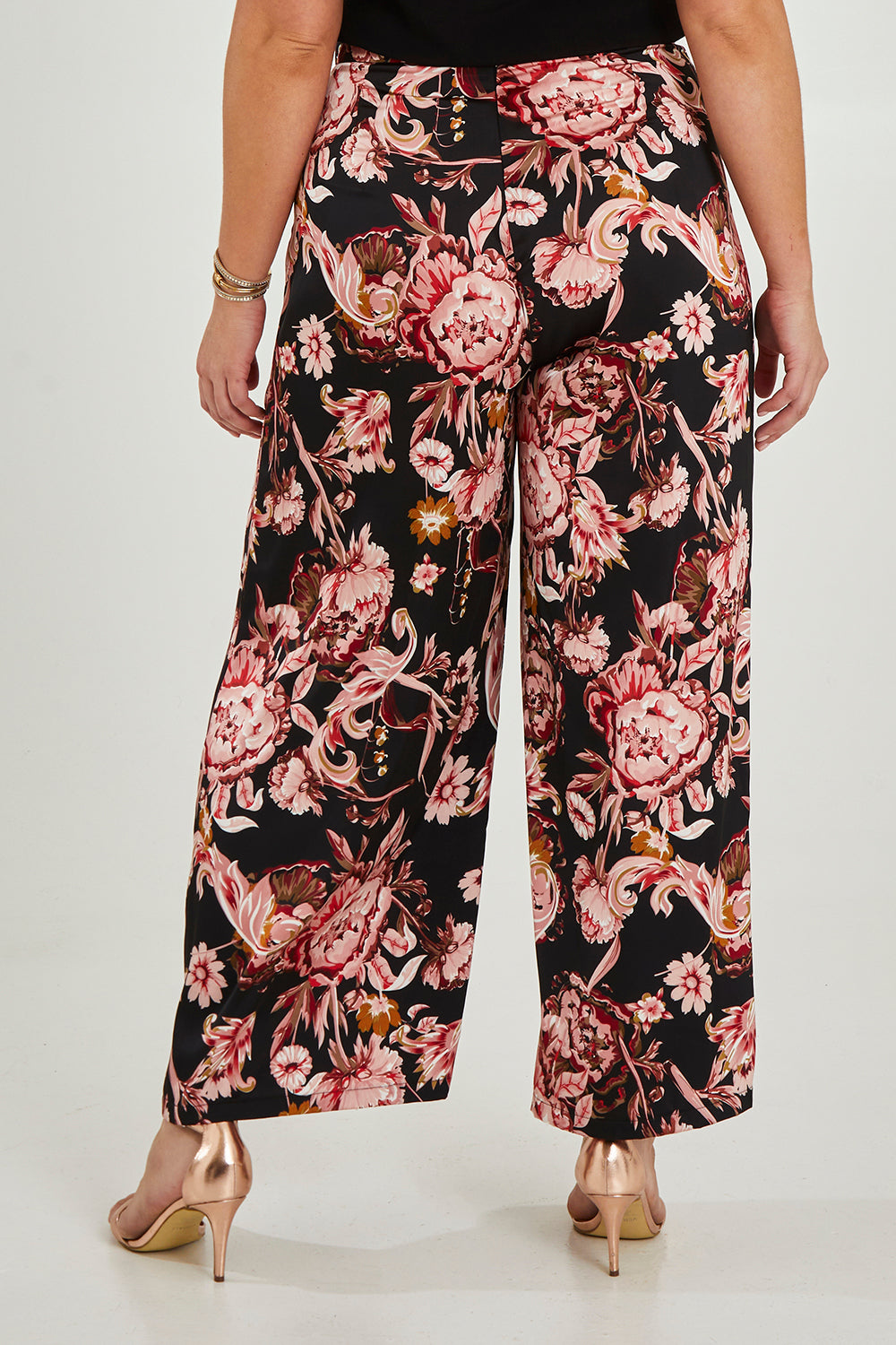 Model Maddy wearing size 16 of the Mia Pants in colour Floral (Black), from the back