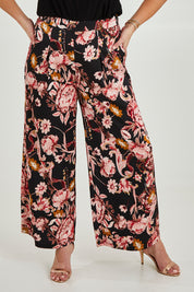 Model Maddy wearing size 16 of the Mia Pants in colour Floral (Black), from the front, cropped image
