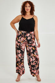 Model Maddy wearing size 16 of the Mia Pants in colour Floral (Black), from the front, showing the whole outfit