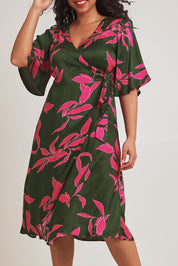 Model Terri-Leigh wearing size 14 of the Ailin Wrap Dress in colour Vividflora (Green), from the front, cropped image