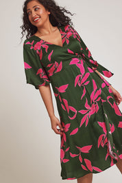 Model Terri-Leigh wearing size 14 of the Ailin Wrap Dress in colour Vividflora (Green), from the front, cropped image