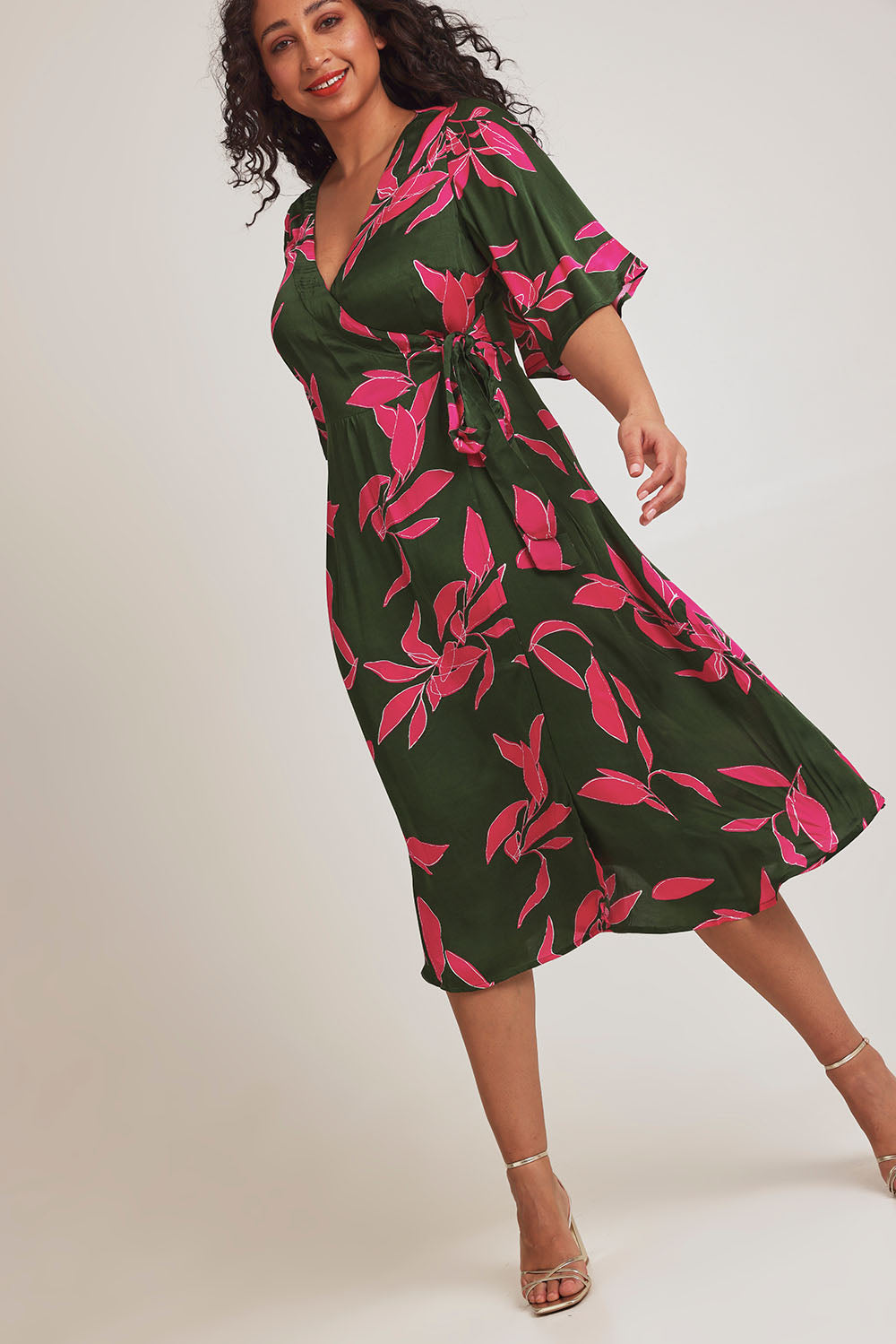 Model Terri-Leigh wearing size 14 of the Ailin Wrap Dress in colour Vividflora (Green), from the front, showing the whole outfit