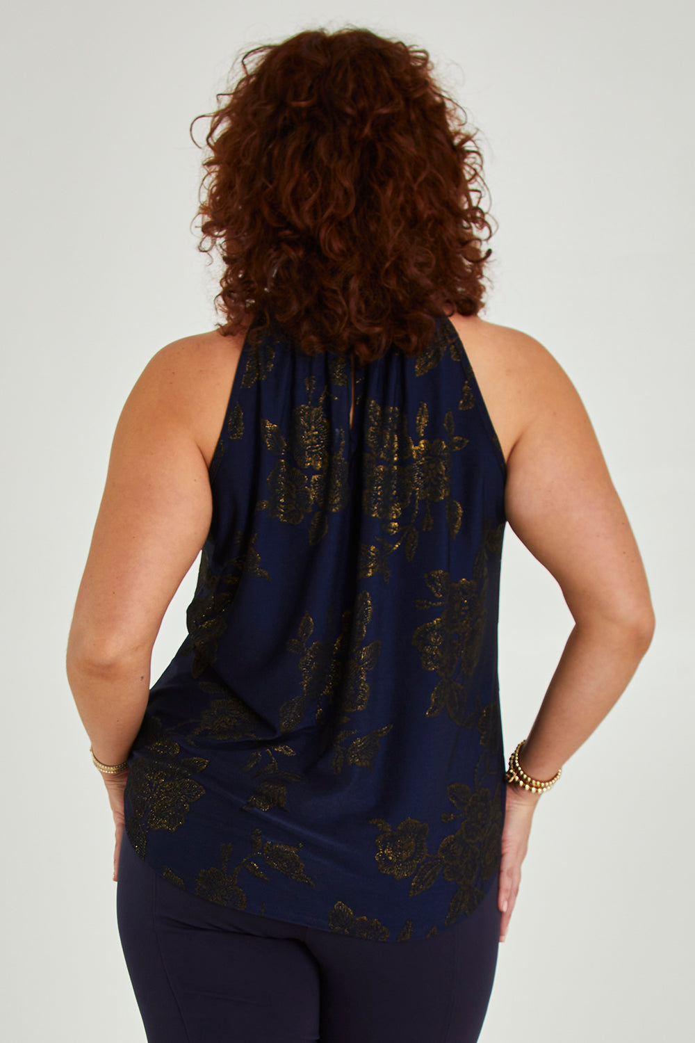 Model Maddy wearing size 16 of the Cara Top in colour Navygold (Blue), from the back