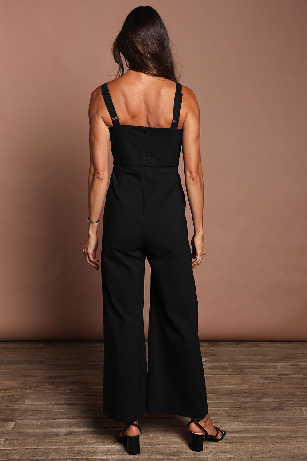 Model Amanda wearing size 10 of the Veronica Jumpsuit in colour Black (Black), from the back