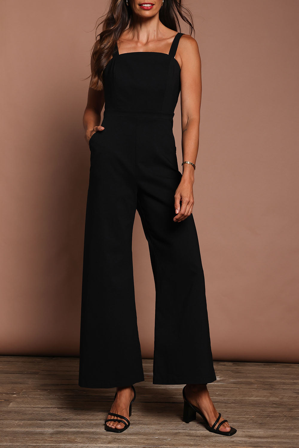 Model Amanda wearing size 10 of the Veronica Jumpsuit in colour Black (Black), from the front, cropped image