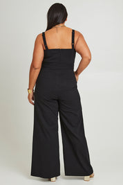 Model Ashleigh wearing size 16 of the Veronica Jumpsuit in colour Black (Black), from the back