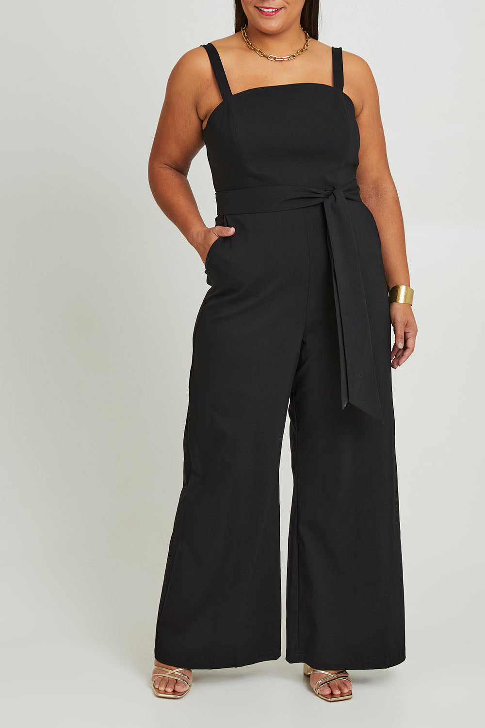 Model Ashleigh wearing size 16 of the Veronica Jumpsuit in colour Black (Black), from the front, cropped image