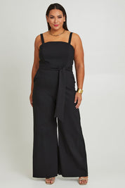Model Ashleigh wearing size 16 of the Veronica Jumpsuit in colour Black (Black), from the front, showing the whole outfit
