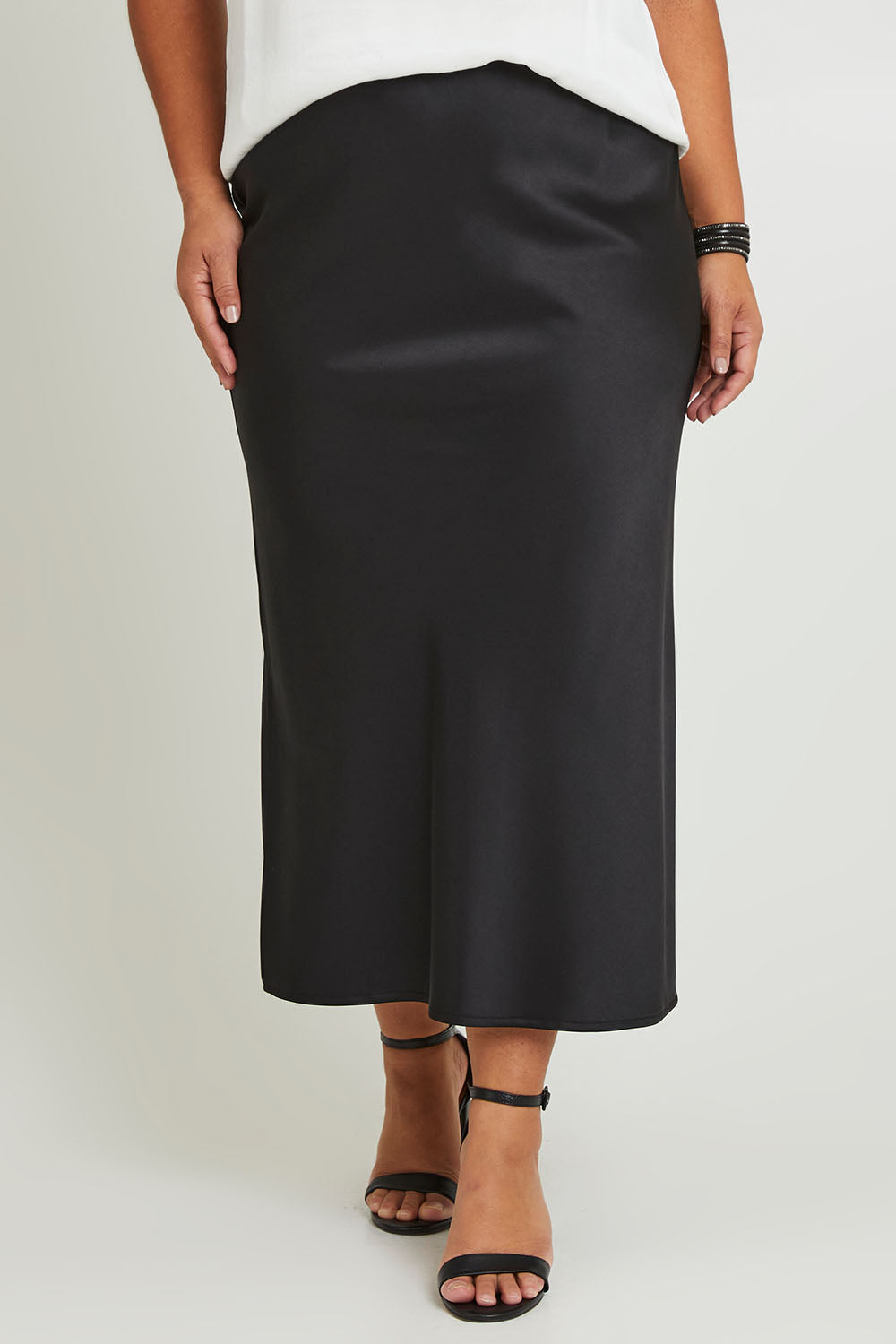 Model Ashleigh wearing size 16 of the Sienna Skirt in colour Black (Black), from the front, cropped image