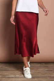 Model Madeline wearing size 10 of the Loulou Satin Skirt in colour Shiraz (Red), from the front, cropped image