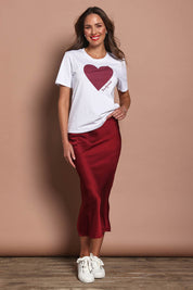 Model Madeline wearing size 10 of the Loulou Satin Skirt in colour Shiraz (Red), from the front, showing the whole outfit