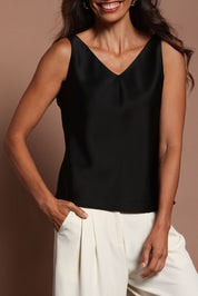 Model Madeline wearing size 10 of the Loulou Satin Camisole in colour Black (Black), from the front, cropped image