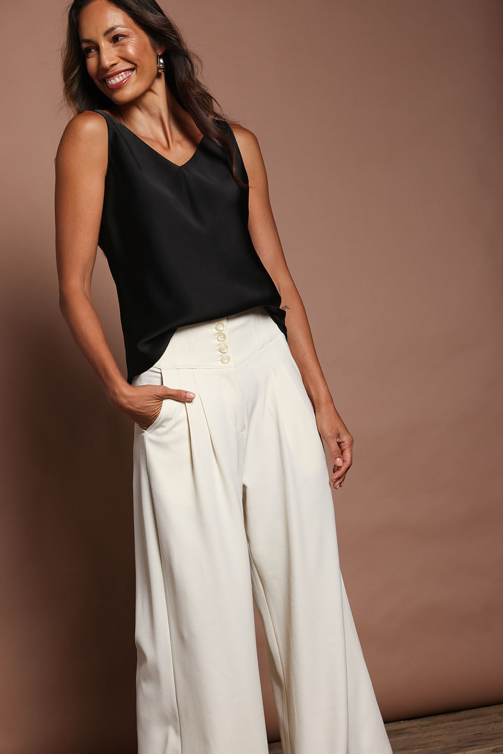 Model Madeline wearing size 10 of the Loulou Satin Camisole in colour Black (Black), from the front, showing the whole outfit